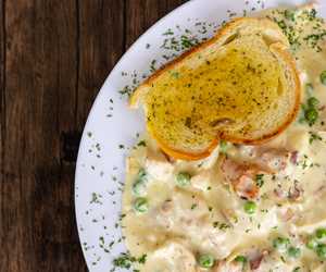 Chicken Carbonara: tender chicken sautéed with sweet peas and bacon in a parmesan cream