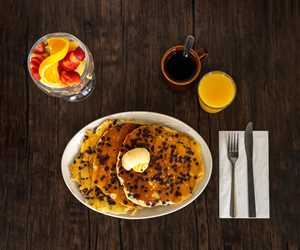 Chocolate Chip Pancakes with a Fruit Cup, Orange Juice, and Coffee